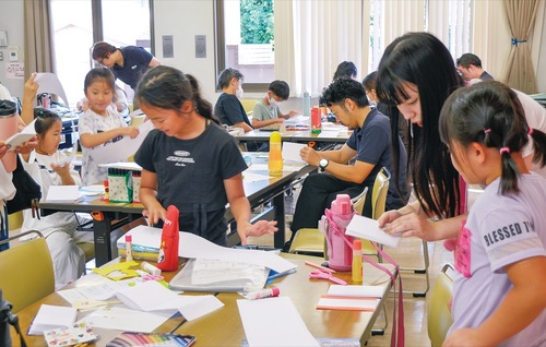 大学生が講師を務めた「ミニ製本制作」開催時の様子＝８月30日