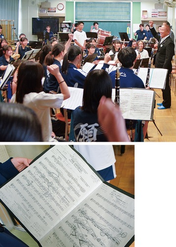 「頑張ろう」と拳を掲げる場面（上）とメモや部員同士で書いたメッセージがびっしり書き込まれた楽譜（下）