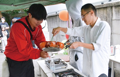 仲間と調理を楽しむ向井さん（右）