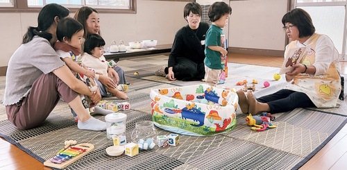 読み聞かせをする田中さん（写真右）と訪れた親子ら