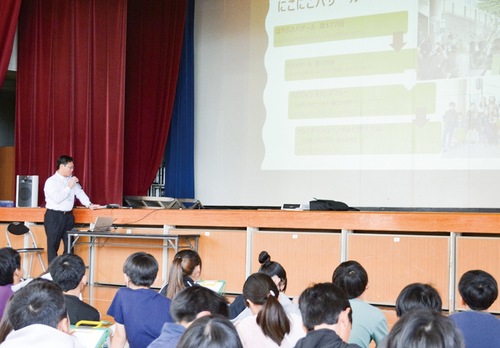 メモを取りながら佐藤会長の話を聞く児童