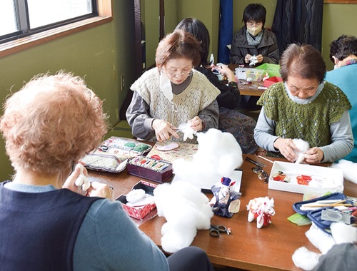 白い「午」の布小物を作る参加者