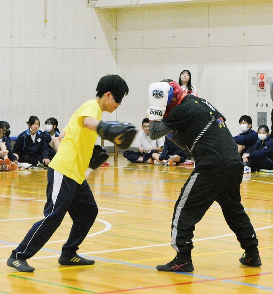 ミット打ちをする工藤さん（左）と村松代表理事（右）