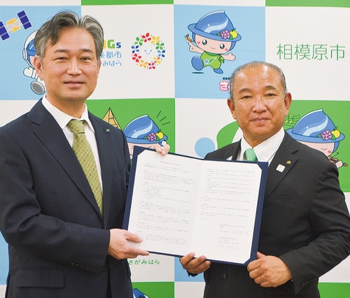 協定書を手にする岡村支社長（左）と本村市長（右）