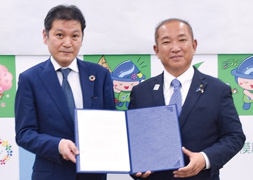 覚書を交わす本村市長（右）と山田ゾーンマネージャー