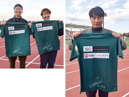 【右】参加した子どもたちに進呈したTシャツを掲げる望月氏。Tシャツには自身のサインがプリントされている／【左】スポンサーの山路フードシステムの伏見彩さん＝右＝と徳橋宏重さん（いずれも11月29日撮影）