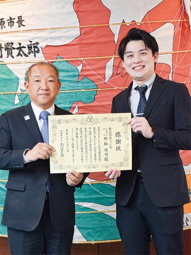 感謝状を持つ本村市長（左）と倍賞店長。倍賞店長は「接客が好き。家電が好き」とのことで同社に就職したという