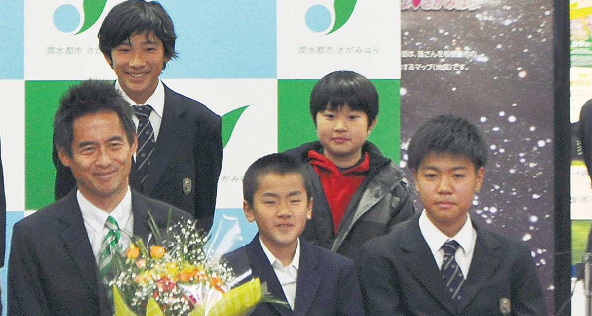 サッカーをしている中学生との記念撮影＝10日、市役所
