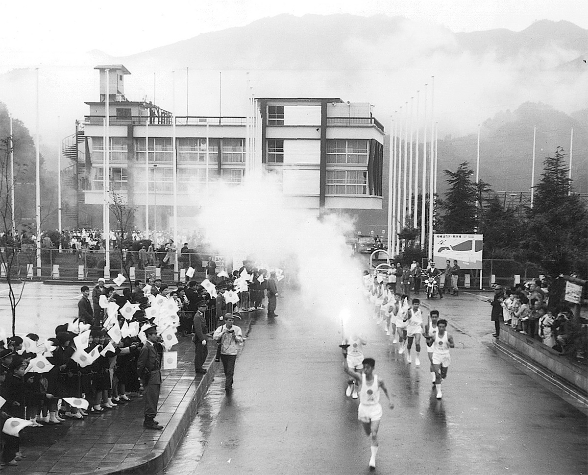 声援を受け、相模湖漕艇場を出発する聖火。先頭が井草さん=1964年10月8日　井草さん提供