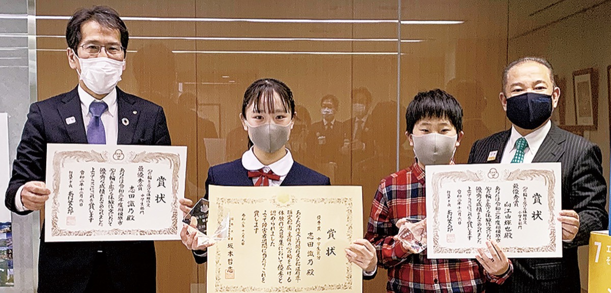 表彰状を手にする志田さん(中央左)と向江さん(中央右)