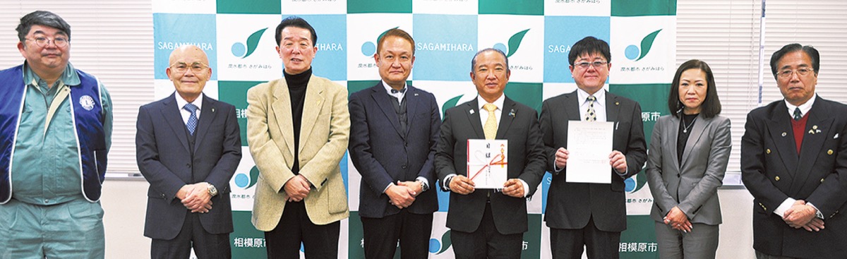 義援金の目録を持つ本村市長（右から４人目）とクラブメンバー。右から３人目が堀内会長