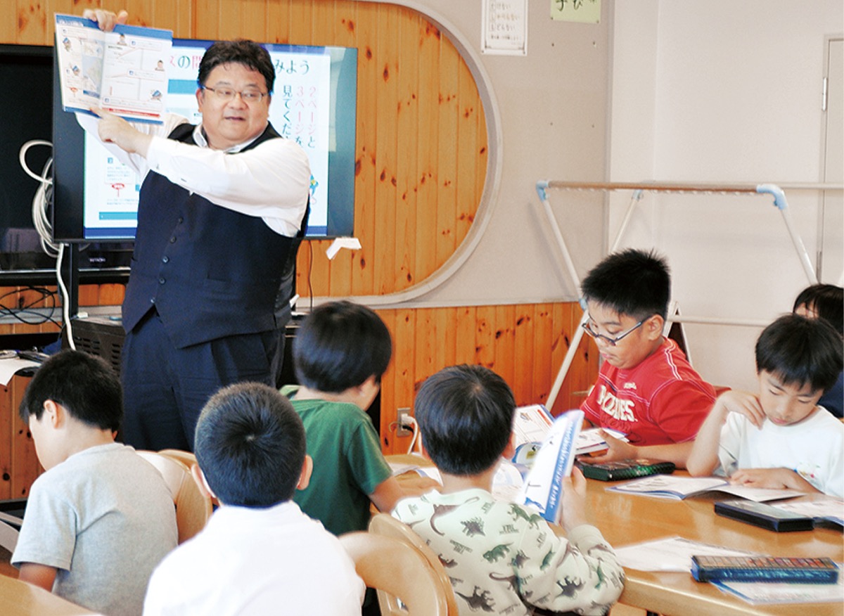 クイズの作り方を説明する荒井さん(奥)と子どもたち