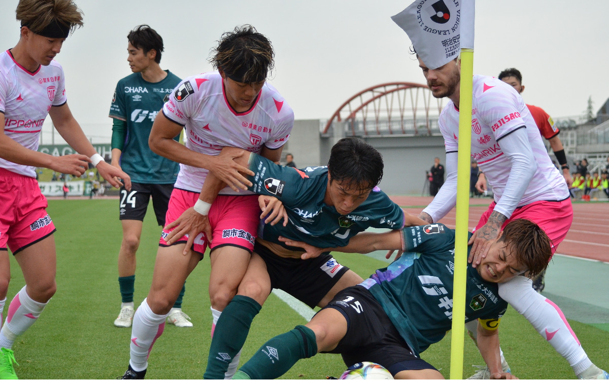 試合終盤、ライン際でボールを守る前田選手と高野遼選手