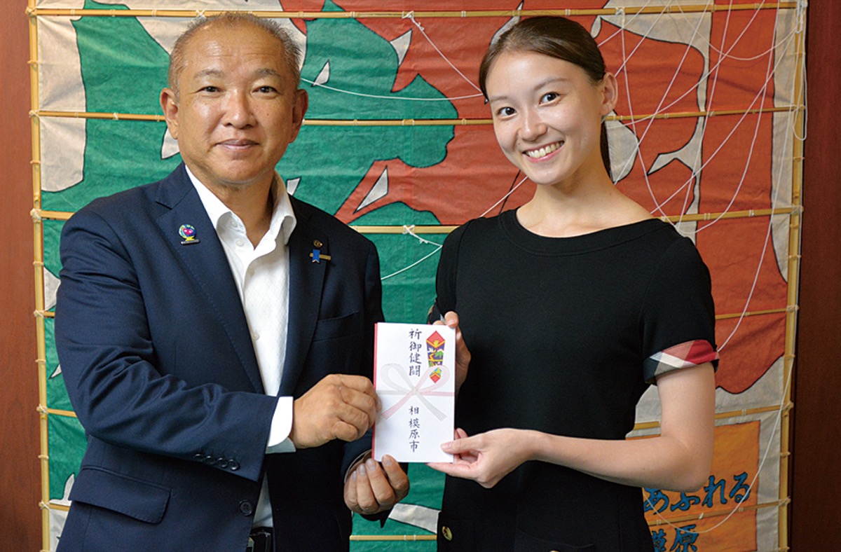 本村市長(左)から渡邊さんに奨励金が手渡された=8月3日、相模原市庁舎