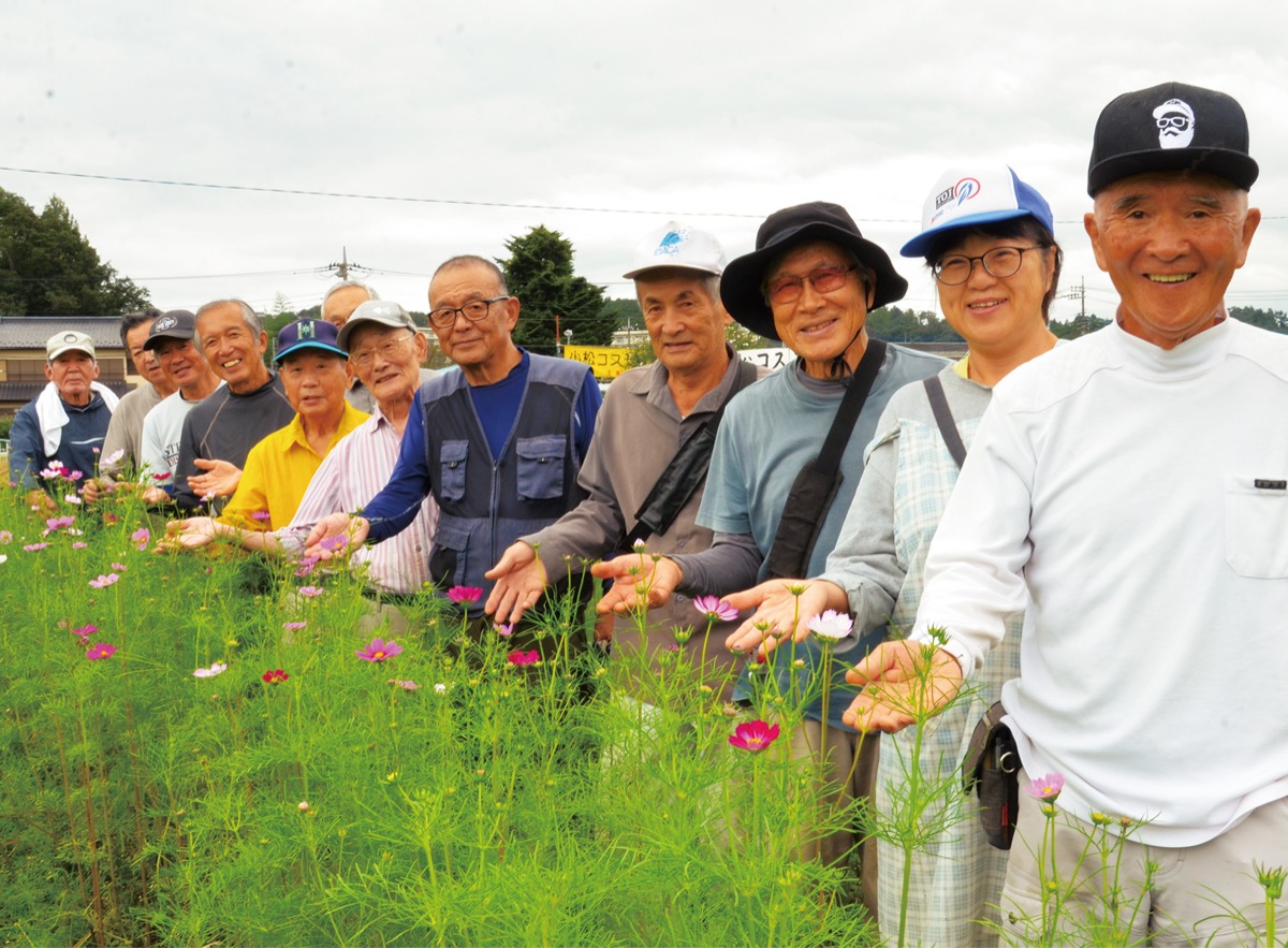 咲き始めた花を前に来場を呼び掛ける実行委員会のメンバー