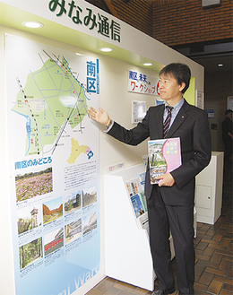 区役所内に新設された情報コーナーを紹介する野村謙一・南区区長。「私のアイデアです」