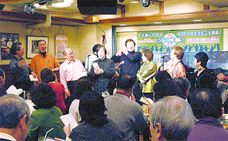 1954年、東京新宿の食堂で自然にうたごえが響き、歌声喫茶『ともしび』が誕生した。以来、58年間、幅広い年代層から圧倒的な支持を受け、営業を続ける。また、店舗だけでなく、今回のような“出前公演”も年間150本近く開催。写真は『ともしび新宿店』の様子