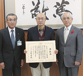 賞状を手にする根岸さん（中央）。右は戸塚英明市社協会長、左は山口和夫副市長