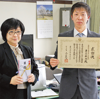 目録を手にする養護学校の岩澤佳代子校長（左）と、神田部会長