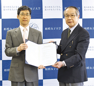協定書を手にする風間学長（左）と宮崎理事長