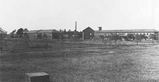 終戦直後の旧陸軍通信学校の構内。兵舎の後方には現存する給水塔（右）と焼却用煙突（左）が見える（相模女子大学八十年史より）