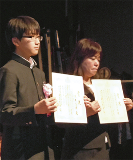 表彰式で表彰状を手にする糸井大揮さん（左）と新井陽子准教授（県教委提供）