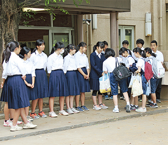 昇降口で募金を呼びかける生徒。写真中央のブレザーを着ているのが本庄さん＝20日、大野南中学校