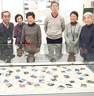 完成したカルタと作成に携わった市民学芸員のメンバー。左から３人目が発起人の横須賀さん