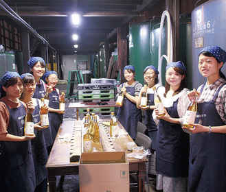 できあがった梅酒を手にする学生たち＝9月6日、久保田酒造