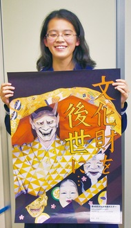 出来立てのポスターを手に笑顔を見せる菊地希望さん