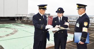 屋上ヘリポートを査察する横田署長（左）と署員