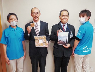記念品を手にする石川理事長（左から2人目）と岩崎施設長（同3人目）