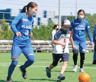 ボールを追いかける参加児童とノジマの選手