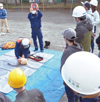 市消防職員らの指導の下、ＡＥＤの使用体験に取り組む地域住民ら＝７日、大野小学校