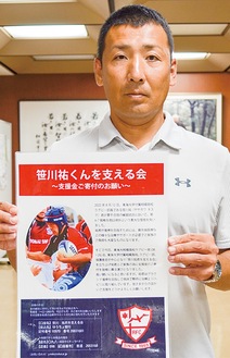 支援の協力を呼びかけるポスターを持つ三木教諭