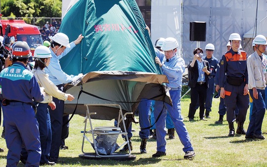 下水道管路のマンホールの上に簡易な便座やパネルを設けて使用するマンホールトイレ。写真は昨年9月1日に相模総合補給廠一部返還地で行われた訓練でトイレを組み立てる岸田首相（右）