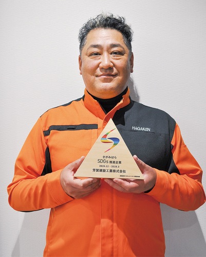 認証の盾を持つ芳賀さん