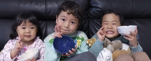 完成した茶碗を持ち喜ぶ子どもたち＝亜月工房提供