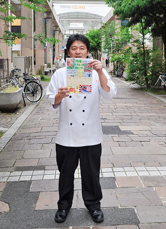 コリドー街でポスターを構える中田さん