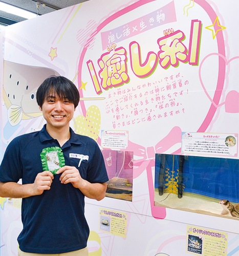 ｢推し｣の生き物の写真を手に笑顔の山田さん