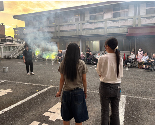 花火を楽しむ入居者と学生＝主催者提供