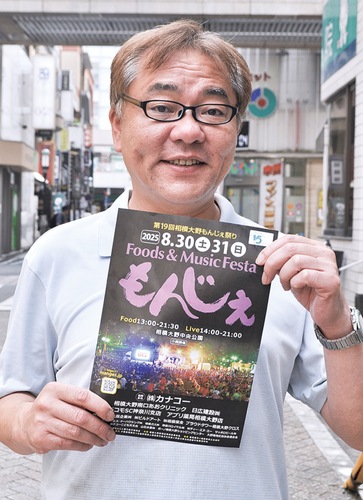 ポスターを手に宣伝する斉藤さん