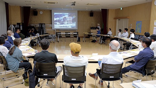 写真を見ながら講演を聞く参加者