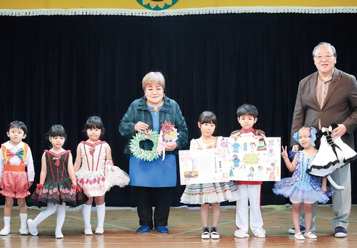 発表会の予行練習の後に行われた授与式。ステージ上で感謝を伝えた園児と吉野社長（中央）、同園の川井俊幸園長（右）