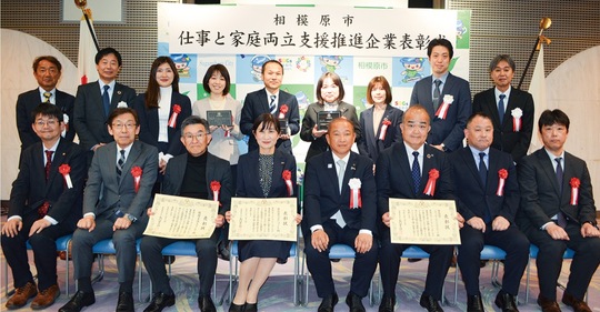 表彰式の様子。前列左から３人目が小久保代表社員。続いて小田中社長、本村賢太郎市長、曽根社長