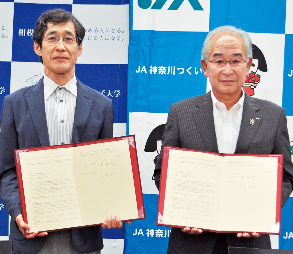 協定書を手に並ぶ中里州克代表理事組合長(右)と風間誠史学長=8月11日、相模女子大学