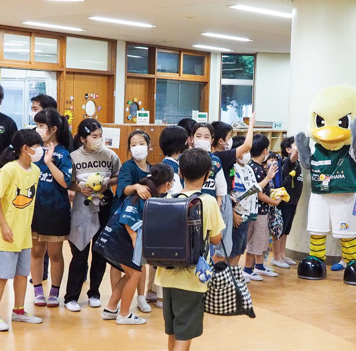 下校する児童にあいさつするガミティら