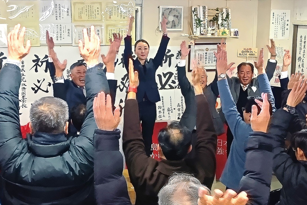 相模原市内の事務所で支援者らと万歳をする金澤氏（中央）