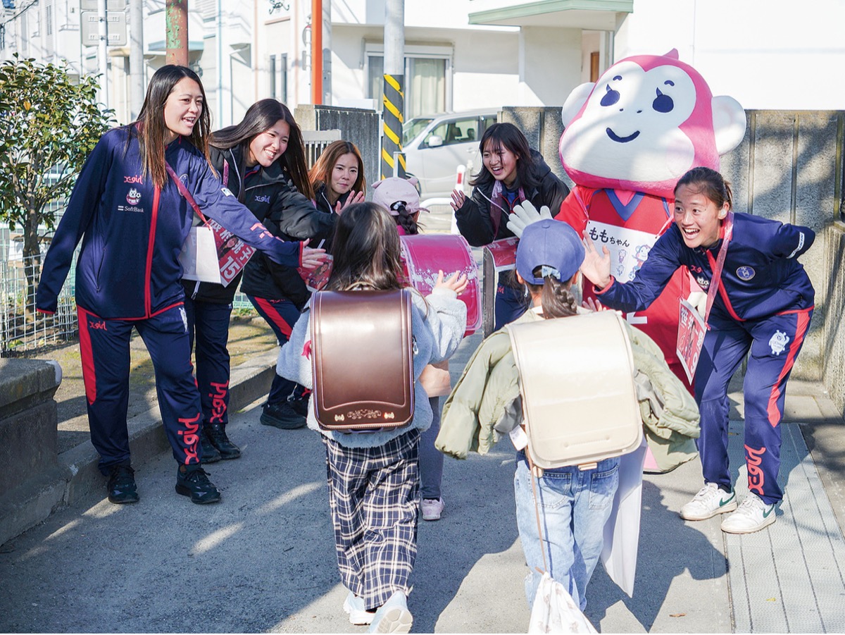 裏門と正門に分かれた選手たち。普段裏門を使う児童が選手に会いに正門まで来る様子も