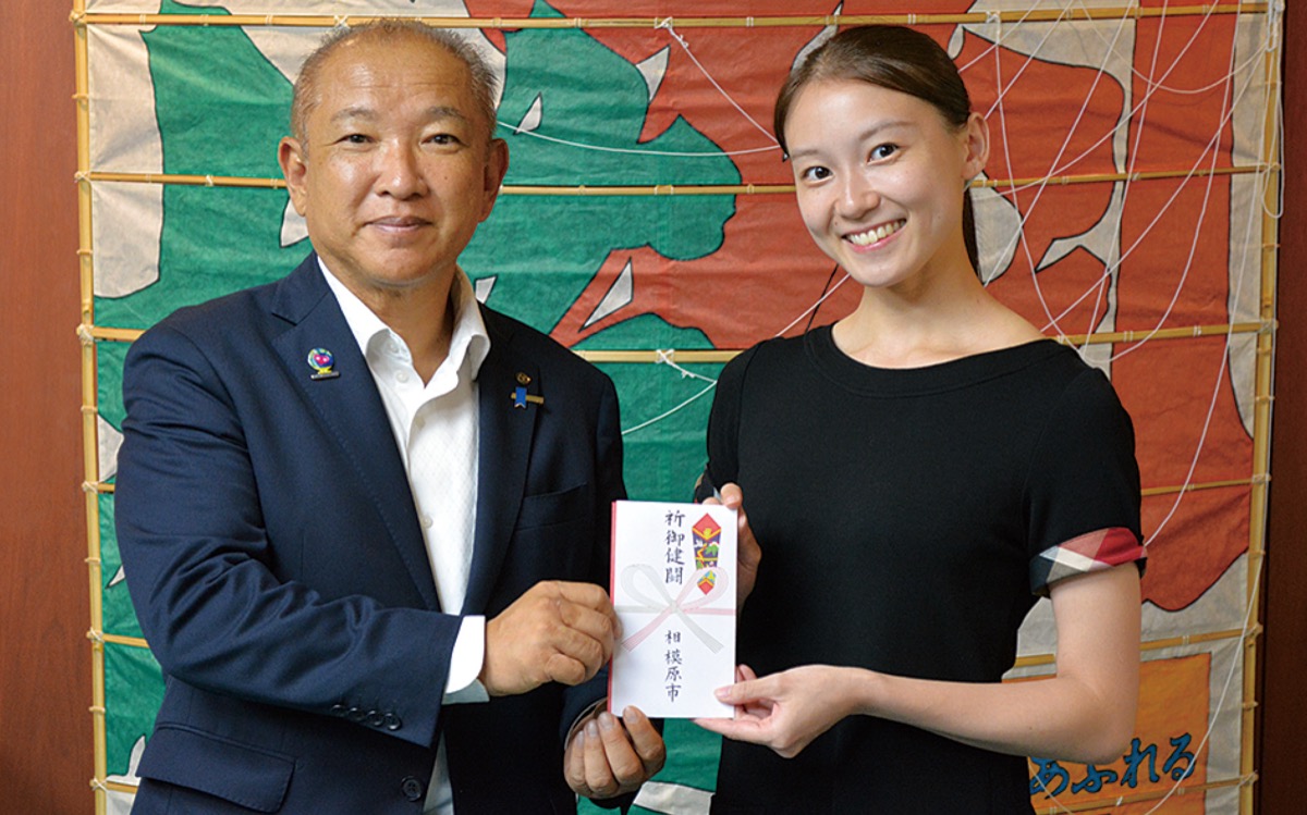 本村市長（左）から渡邊さんに奨励金が手渡された＝8月3日、相模原市庁舎